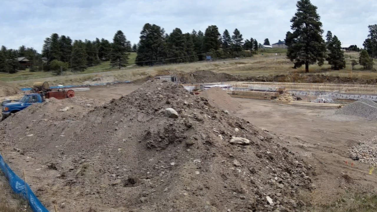 Timelapse of a dental clinic among pines, from a dirt pad to a finished building and paved lot