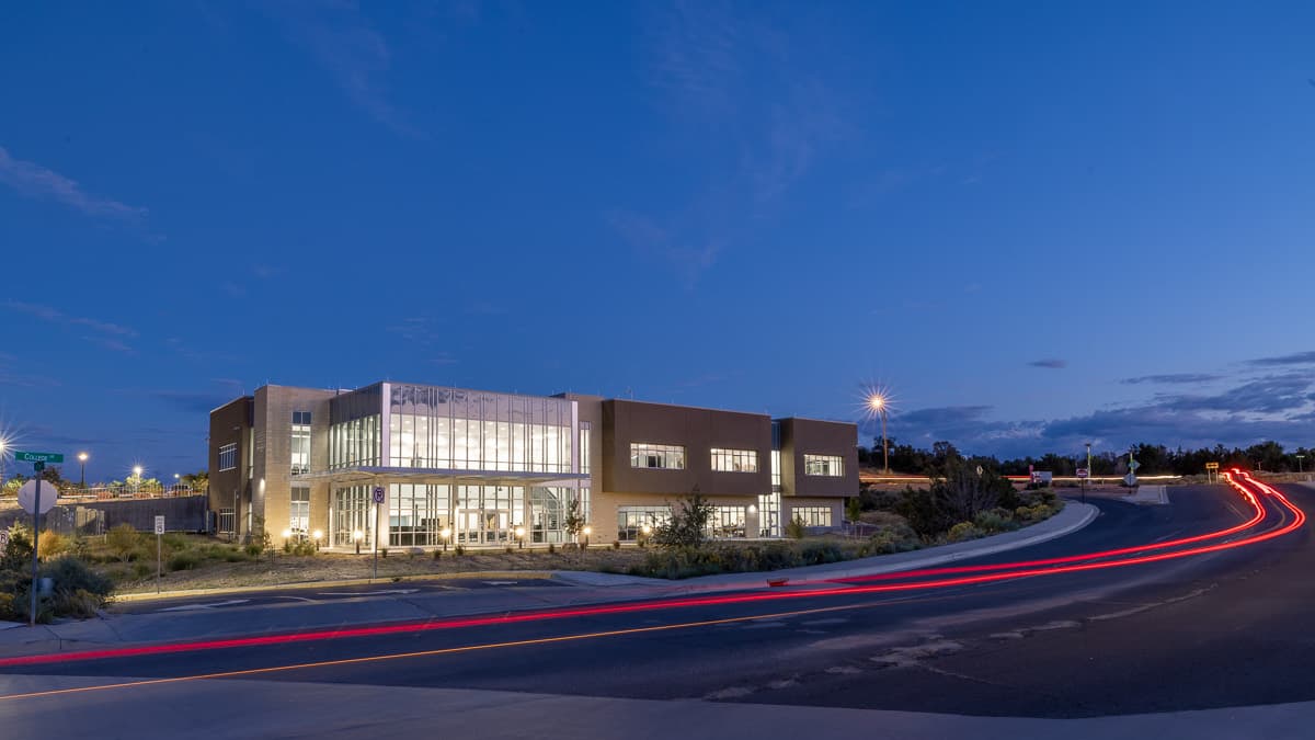 McKinley Academy at dusk, tail lights streaking past on the curve in front